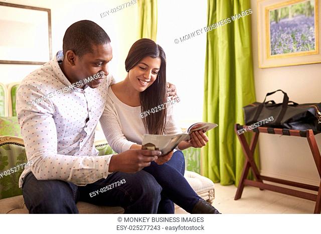 Young couple read a guide brochure together in a hotel room