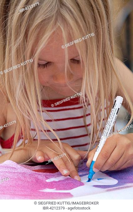 Little girl painting on fabric