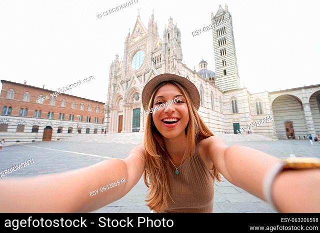Holidays in Italy. Brazilian girl takes selfie picture with smartphone in Siena, Tuscany, Italy