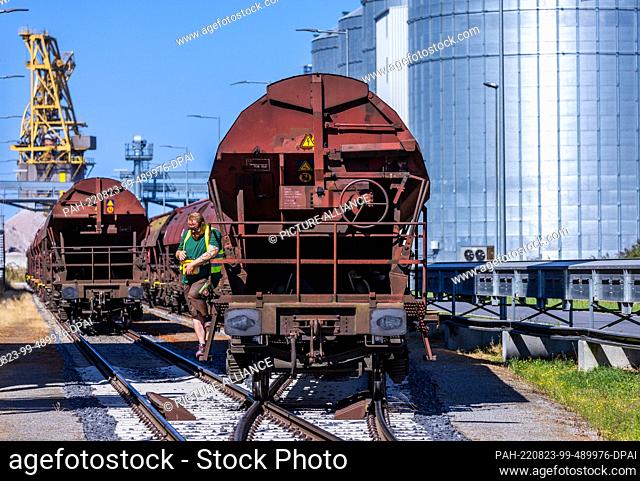 23 August 2022, Mecklenburg-Western Pomerania, Rostock: Wagons of the first freight train with corn from Ukraine are pushed to the grain terminal in the Port of...
