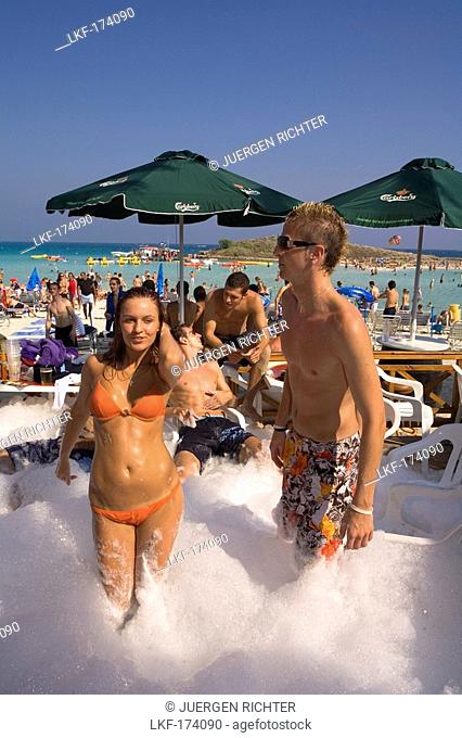 A young couple dancing at a foam party, beach party, Nissi Beach, Agia Napa, South Cyprus, Cyprus