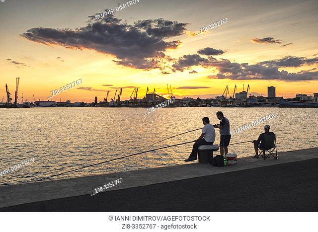 Anglers against the setting sun in the Port of Burgas, Bourgas, Bulgaria