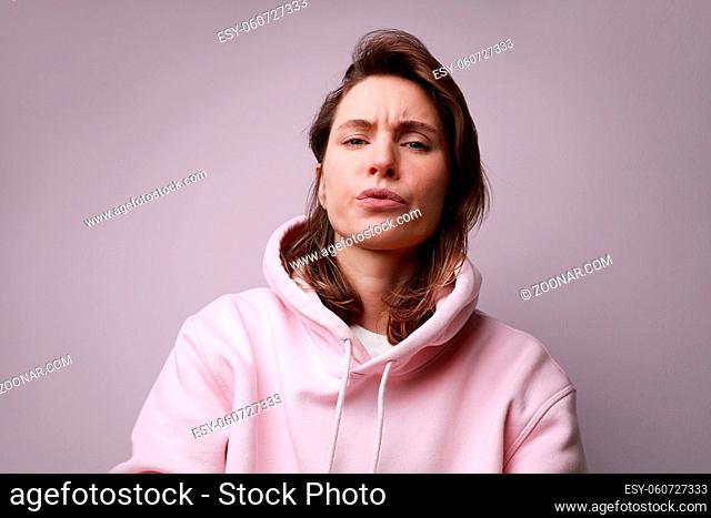 Young woman with shocked and angry face expression, posing on white background wall. High quality photo