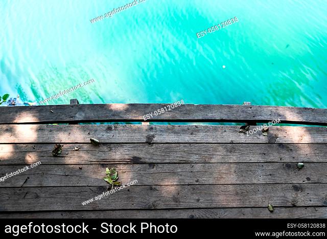Rustic wooden dock pier and blue lake, text space