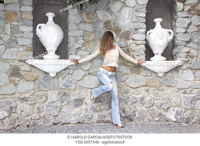 Beautiful woman close to ceramic jars posing for the camera in different sensual positions in Yalta, Crimea
