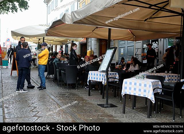 People have a drink on a bar terrace at the Navigli in downtown Milan on April 26, 2021 as bars, restaurants, cinemas and concert halls partially reopen across...