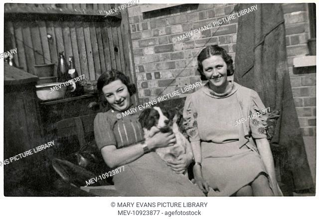 Two women with a dog in a back garden, dated August 1931