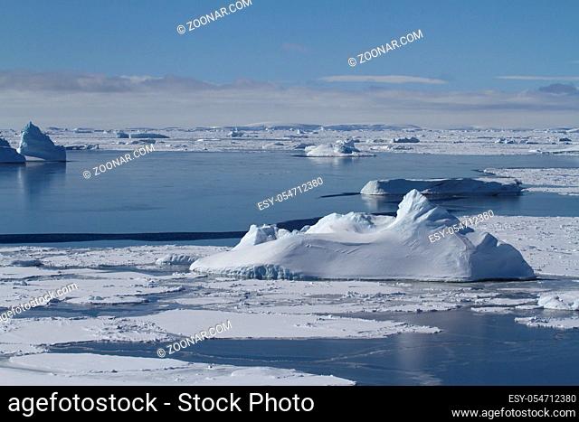 ice field and many small icebergs in the strait near the Anatrctic peninsula on a spring day