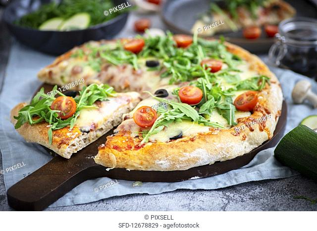 Pizza with prosciutto, mozzarella and vegetables