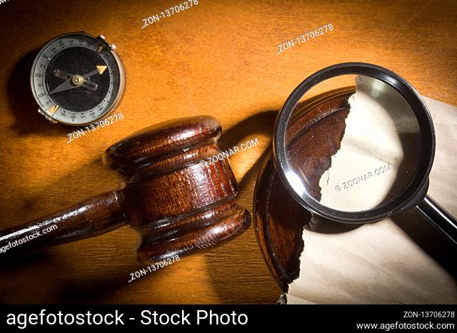 Judge's gavel and magnifier on a wooden table