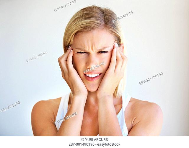 Portrait of beautiful Caucasian woman with severe headache holding head over white background