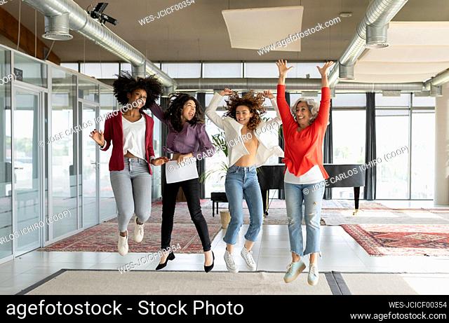 Happy businesswomen jumping in office