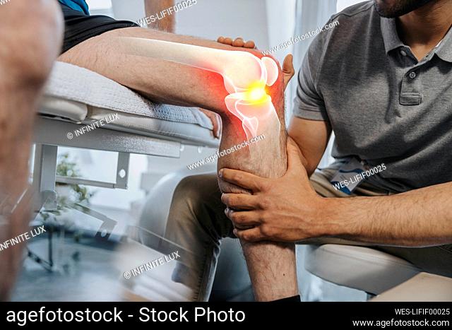 Physical therapist checking knee joint of patient at medical examination room