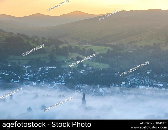 Sunrise at Lake Windermere with early morning mist and fog sweeping over the landscape. Photographed from Loughrigg Fell, above Clappersgate, near Ambleside