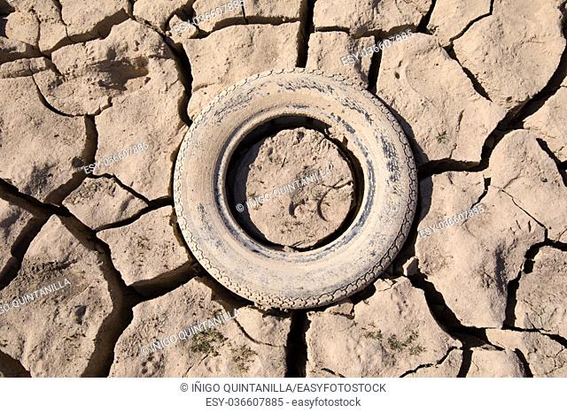 background detail of abandoned tire embedded in dry land, drought in Entrepenas reservoir, in Guadalajara, Castilla, Spain Europe