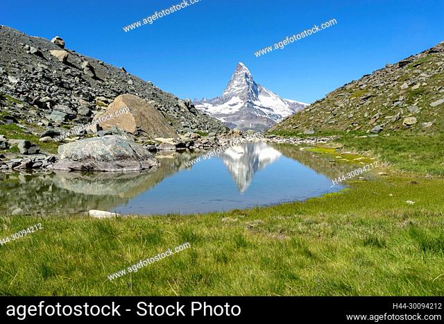 Das Matterhorn spiegelt sich in einem namelosen See bei der Fluhalp, bei Zermatt, Kanton Wallis