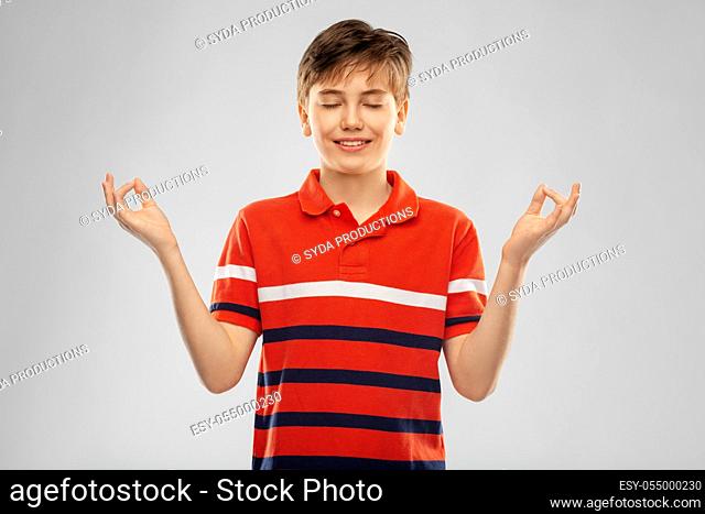 happy smiling meditating boy in red polo t-shirt
