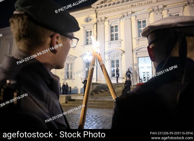 05 December 2023, Berlin: A soldier from the guard battalion lights a new torch in front of the Red Carpet at Bellevue Palace