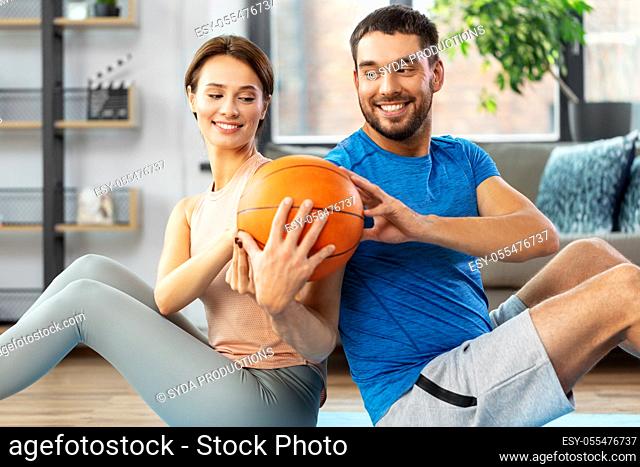 happy couple exercising with ball at home