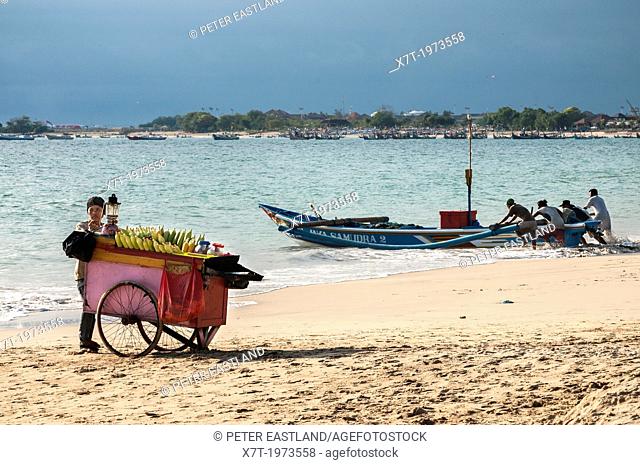 Fishing boats and corn cob vendors on the beach at Jimbaran, southern Bali, Indonesia