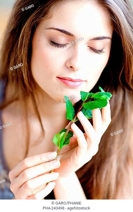 Woman smelling mint leaves Mentha sp.