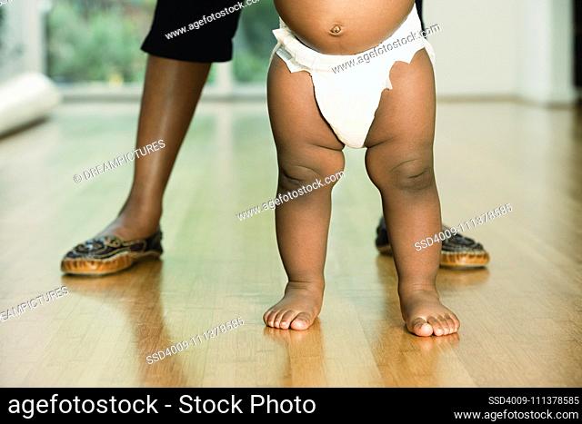 African baby standing with mother