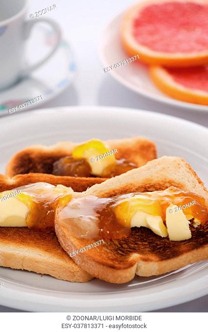 French toast and sliced orange on white tablecloth