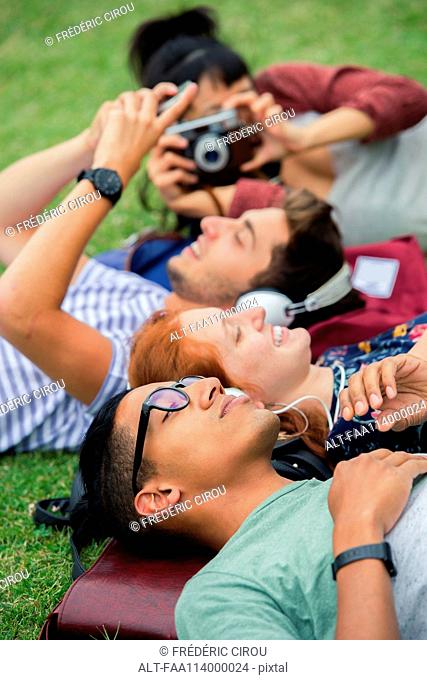 College friends relaxing together on grass