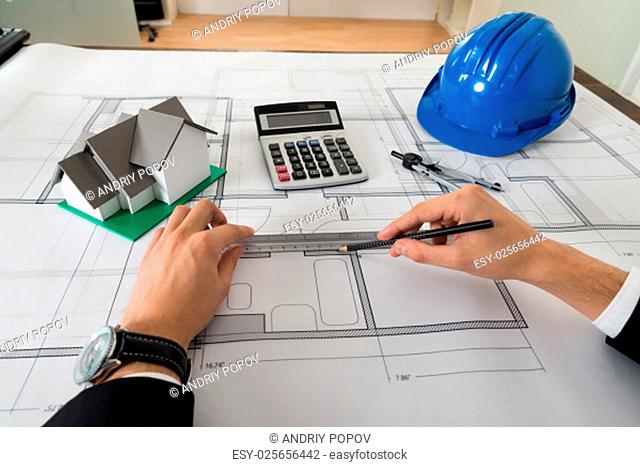 Close-up Of Male Architect Working On Blueprint In Office