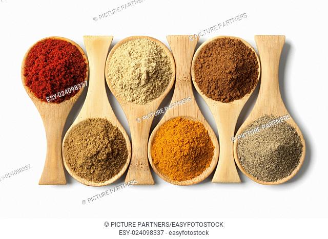 Variety of dried herbs and spices on wooden spoons