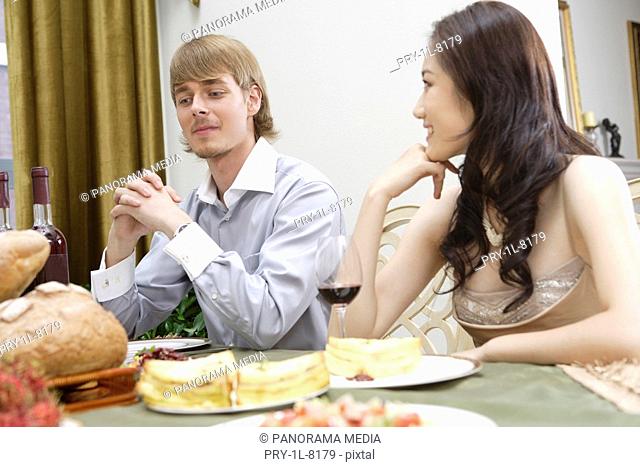 Young man and woman sitting at dining table