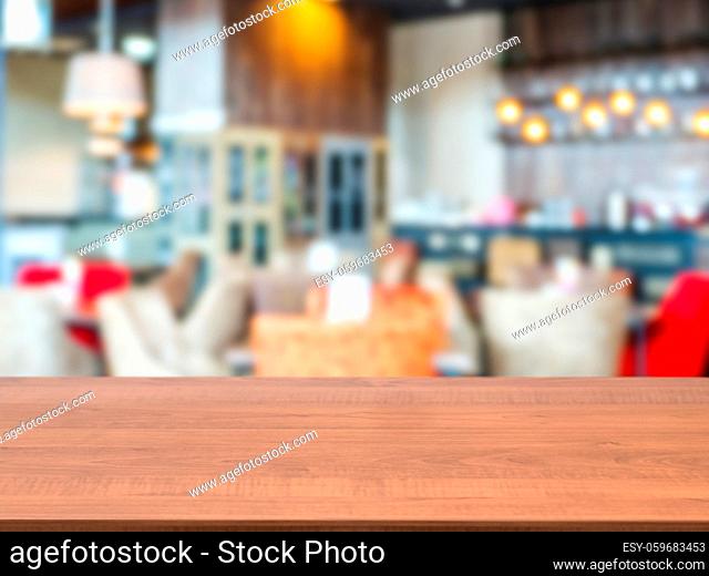 Dark wooden board empty table in front of blurred background. Perspective brown wood over blur in cafe interior - can be used for display or montage our...