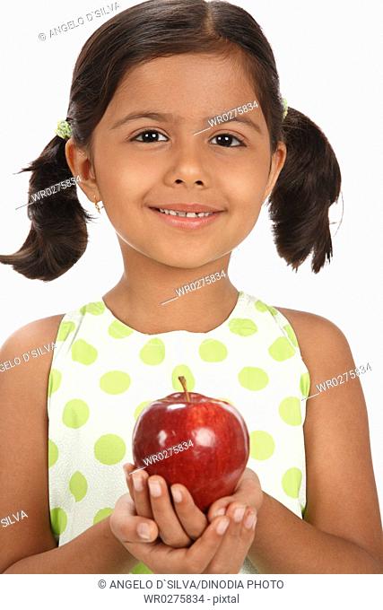 Eight year old girl kept red apple in both hands MR703U
