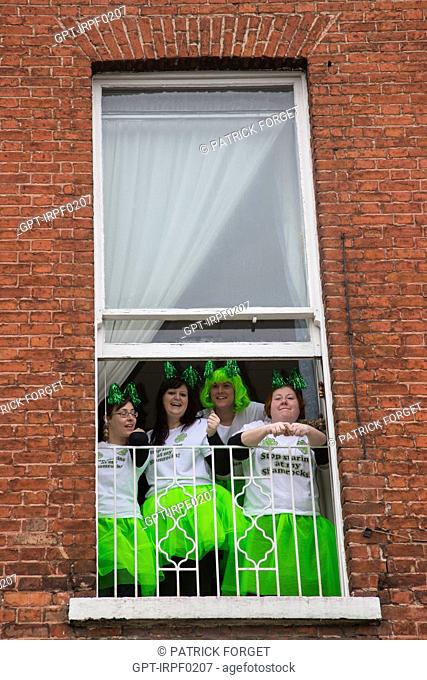 WOMEN WEARING THE GREEN COLOUR OF THE IRISH CLOVER, SPECTATORS ON THE BALCONIES AND AT WINDOWS FOR SAINT PATRICK‚ÄôS DAY, DUBLIN, IRELAND