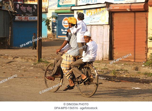 Black ribbon on shoulder to protest against bomb blast occurred on 29th September 2008 ; man riding bicycle with his sons in textile town of Malegaon ;...