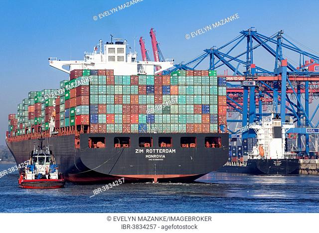 Fully loaded container ship, departure with tug boat, Waltershofer Hafen, Hamburg, Germany