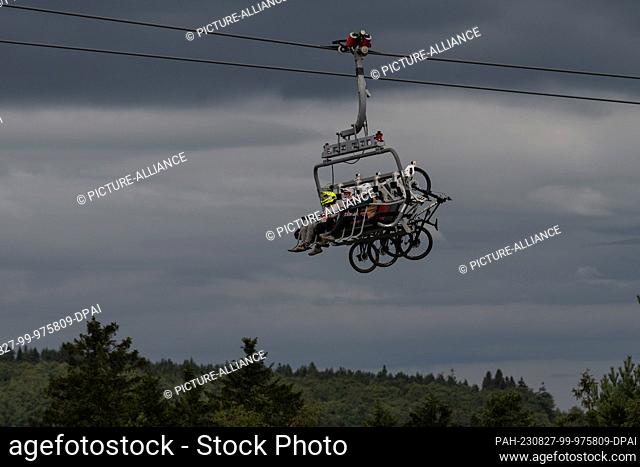27 August 2023, Hesse, Willingen: Cyclists sit with their mountain bikes in the K1 chairlift on the Ettelsberg. Photo: Swen Pförtner/dpa