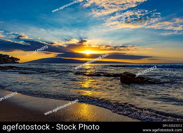 View of the ocean waves at sunset from Ka'anapali Beach with the Island of Lanai on the horizon; Ka'anapali, Maui, Hawaii, United States of America