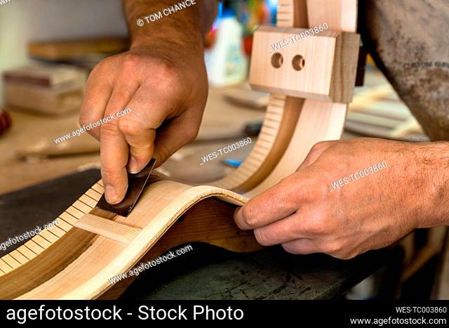 Guitar maker in his workshop, close-up