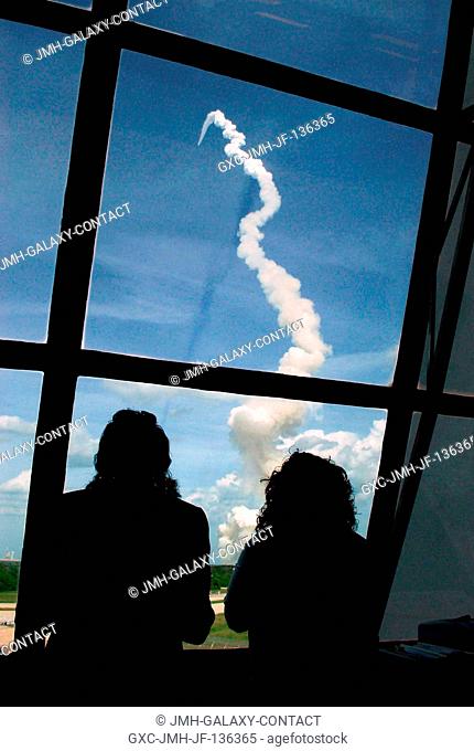 View of personnel watching the launch of the Space Shuttle Atlantis through the windows of the Launch Control Center at the Kennedy Space Center (KSC)