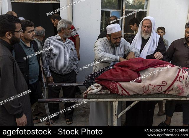 21 June 2023, Syria, Kafr Nuran: Relatives shroud the body of a man who was killed in artillery shelling by the Syrian regime that targeted the village of Kafr...