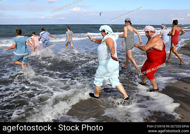 18 September 2021, Mecklenburg-Western Pomerania, Heiligendamm: In Germany's oldest seaside resort, the participants in the ""Abbaden"" go into the 17 degree...