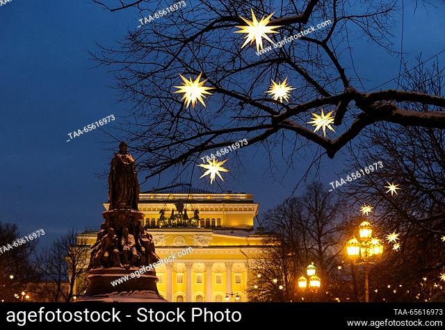 RUSSIA, ST PETERSBURG - DECEMBER 10, 2023: Star-shaped lights hang from tree branches, with the Alexandrinsky Theatre in the background