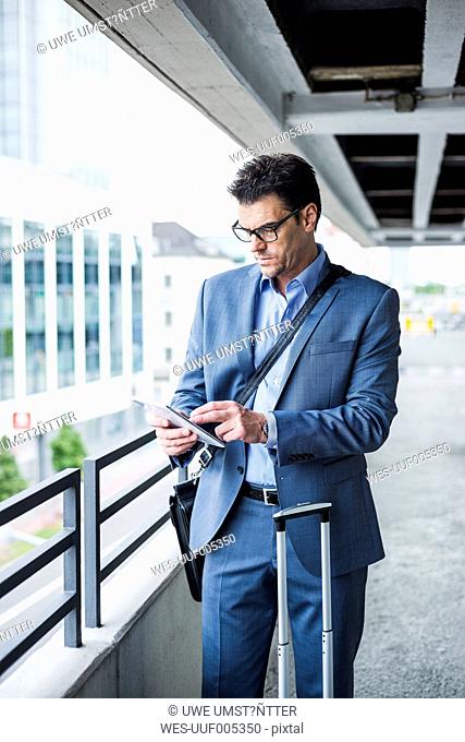 Businessman on business trip using his mini tablet