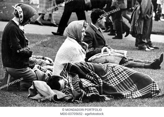 British people lying on the grass near the port waiting for the arrival of Sir Francis Chichester on the return from his journey around the World