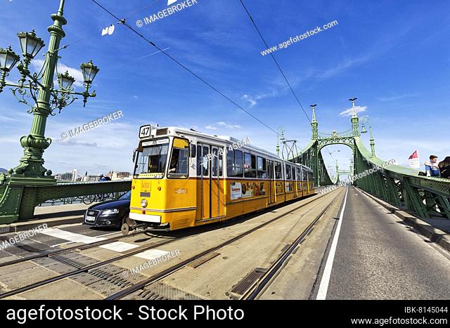 Yellow tram and bridge gate on the Freedom Bridge, Buda, Budapest, Hungary, Europe