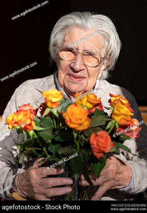 13 February 2021, Baden-Wuerttemberg, Stuttgart: Mina Hehn has a bouquet of flowers on her lap in her patio entrance at a nursing home on her 108th birthday