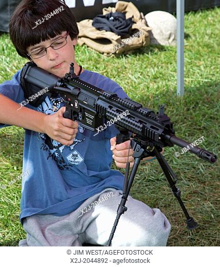 New Boston, Michigan - A Cub Scout with an automatic weapon at a Marine Corps booth during a weekend gathering at a suburban Detroit park