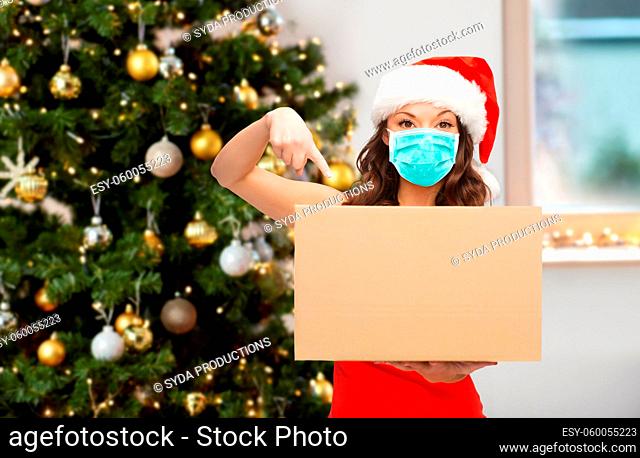 woman in mask with parcel box on christmas