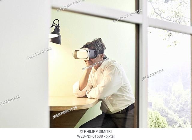 Businessman wearing VR glasses in modern office